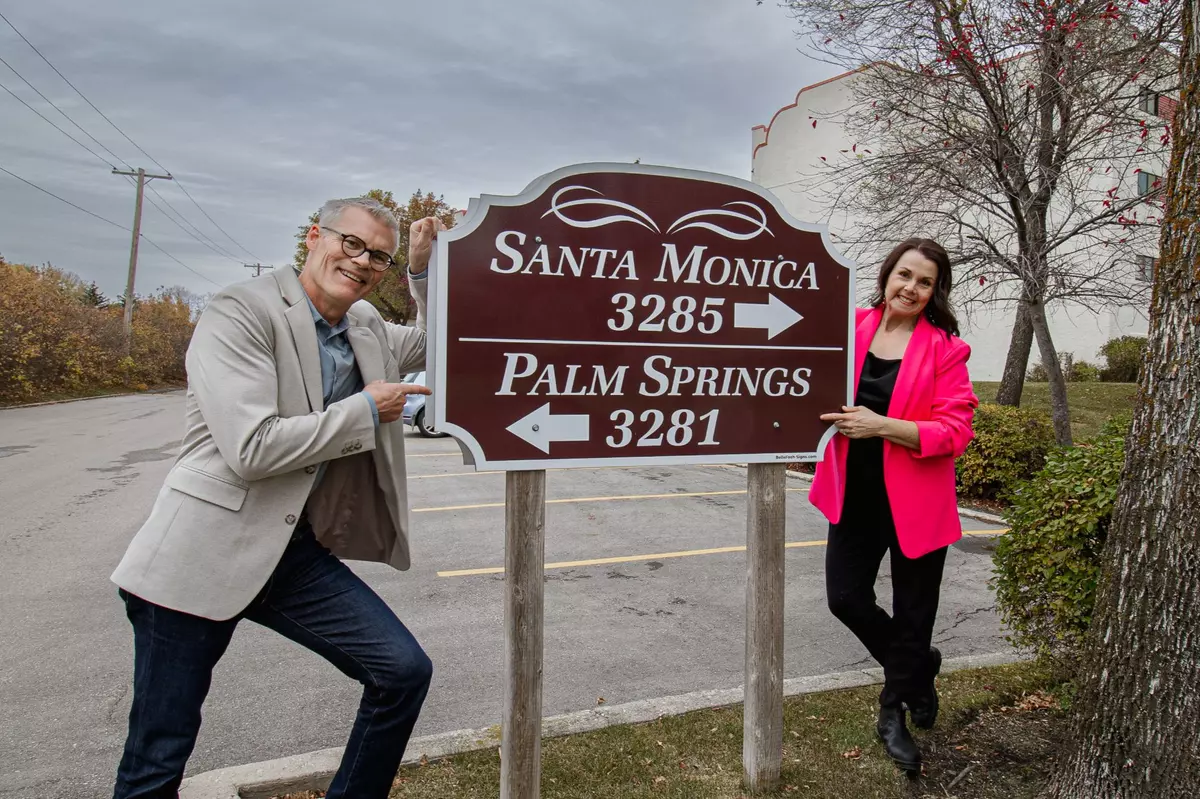 Karen and Jeff stand in front of Palm Springs Condo sign