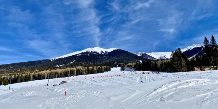 A breathtaking image of snow-covered slopes at a ski resort in Arizona, with the San Francisco Peaks in the background under a bright blue sky. This photo captures a lesser-known side of Arizona, showcasing that the state, while famous for its desert landscapes, also experiences significant snowfall in higher elevation areas like Flagstaff. Offering opportunities for skiing, snowboarding, and winter recreation, Arizona's northern regions provide a perfect winter getaway just a few hours from the Phoenix metro area.