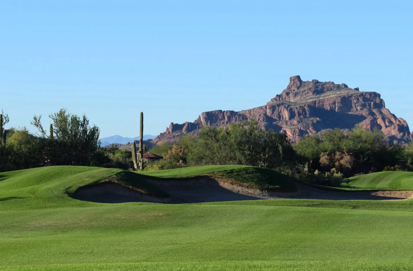 Sunny day at Las Sendas Golf Course in Mesa, Arizona, featuring green fairways, desert cacti, and rugged mountain views under clear blue skies, showcasing Arizona's warm, favorable weather perfect for outdoor recreation year-round.