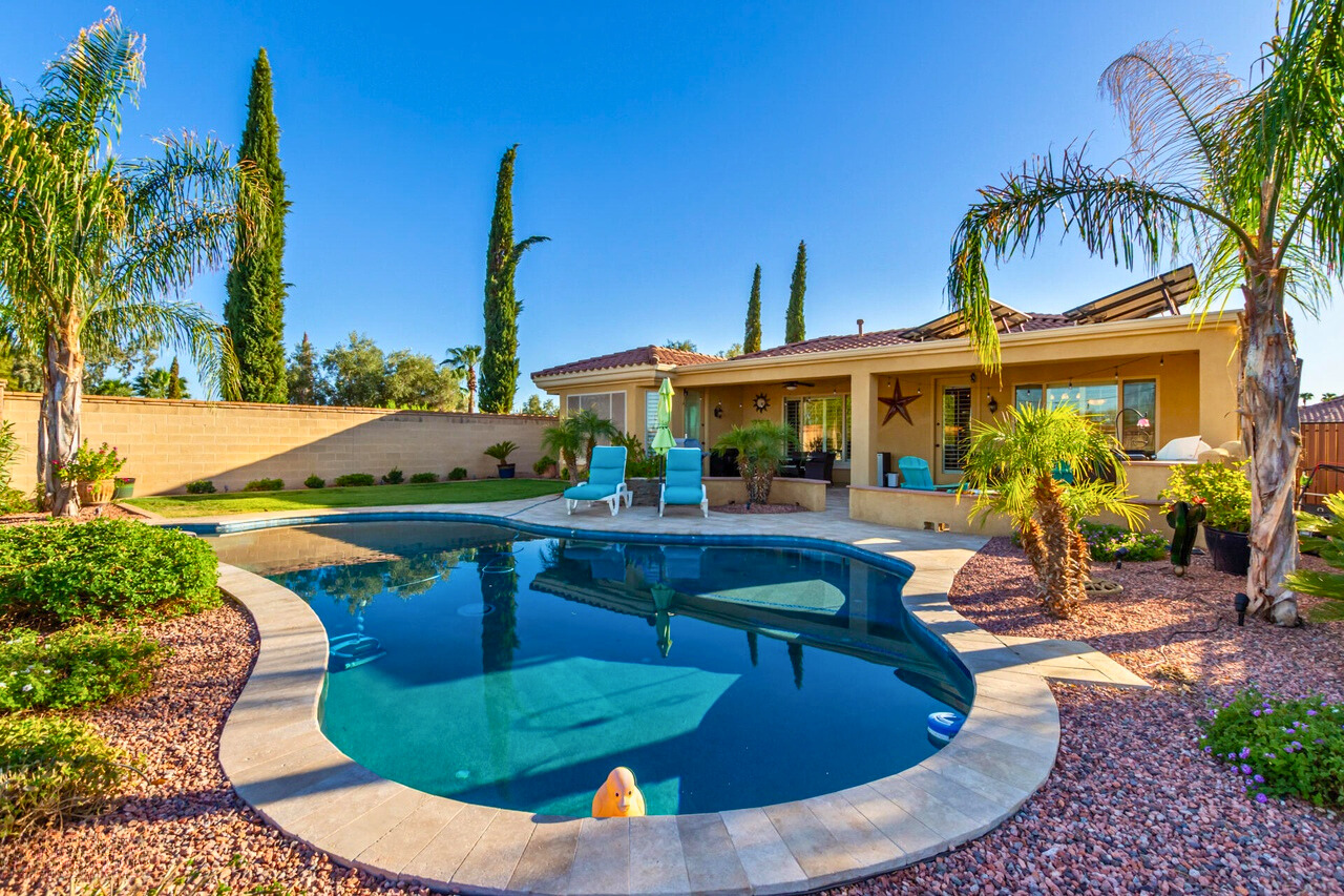 Beautiful backyard of a Corte Bella home in Sun City West, AZ, featuring a private pool, lush landscaping, and spacious outdoor living areas, showcasing the luxurious homes available for every lifestyle in this 55+ active adult community.