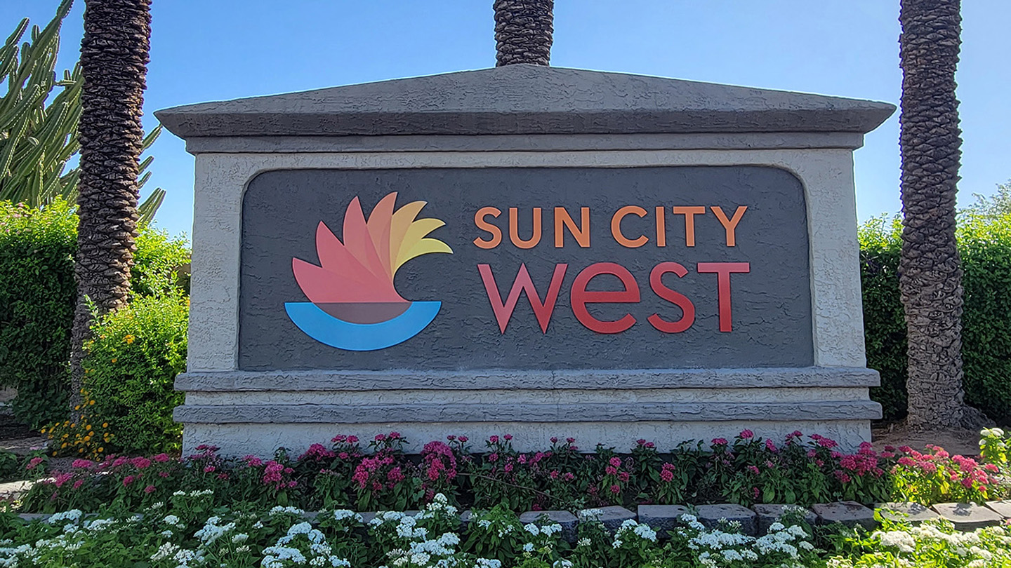 Entrance sign to Sun City West, AZ, featuring vibrant landscaping and iconic branding, representing the premier 55+ active adult community known for its exceptional amenities, recreational opportunities, and welcoming lifestyle.