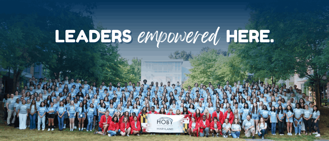 Group photo of HOBY Maryland participants and volunteers gathered outdoors, with the text 'Leaders Empowered Here' displayed at the top and the HOBY Maryland banner in the front