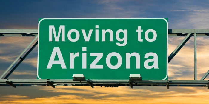 Highway sign reading 'Moving to Arizona' against a colorful sunset sky, symbolizing the growing trend of Californians relocating to Arizona for its affordable housing, lower taxes, strong job market, and desirable quality of life.