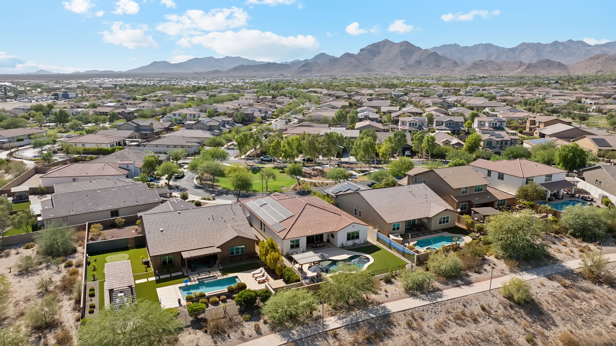 Aerial view of a home for sale in the popular Verrado neighborhood, showcasing its lush landscaping, private pool, and mountain views. With increased competition in the housing market, sellers in neighborhoods like Verrado need to stand out by highlighting unique features and presenting move-in-ready properties to attract buyers.