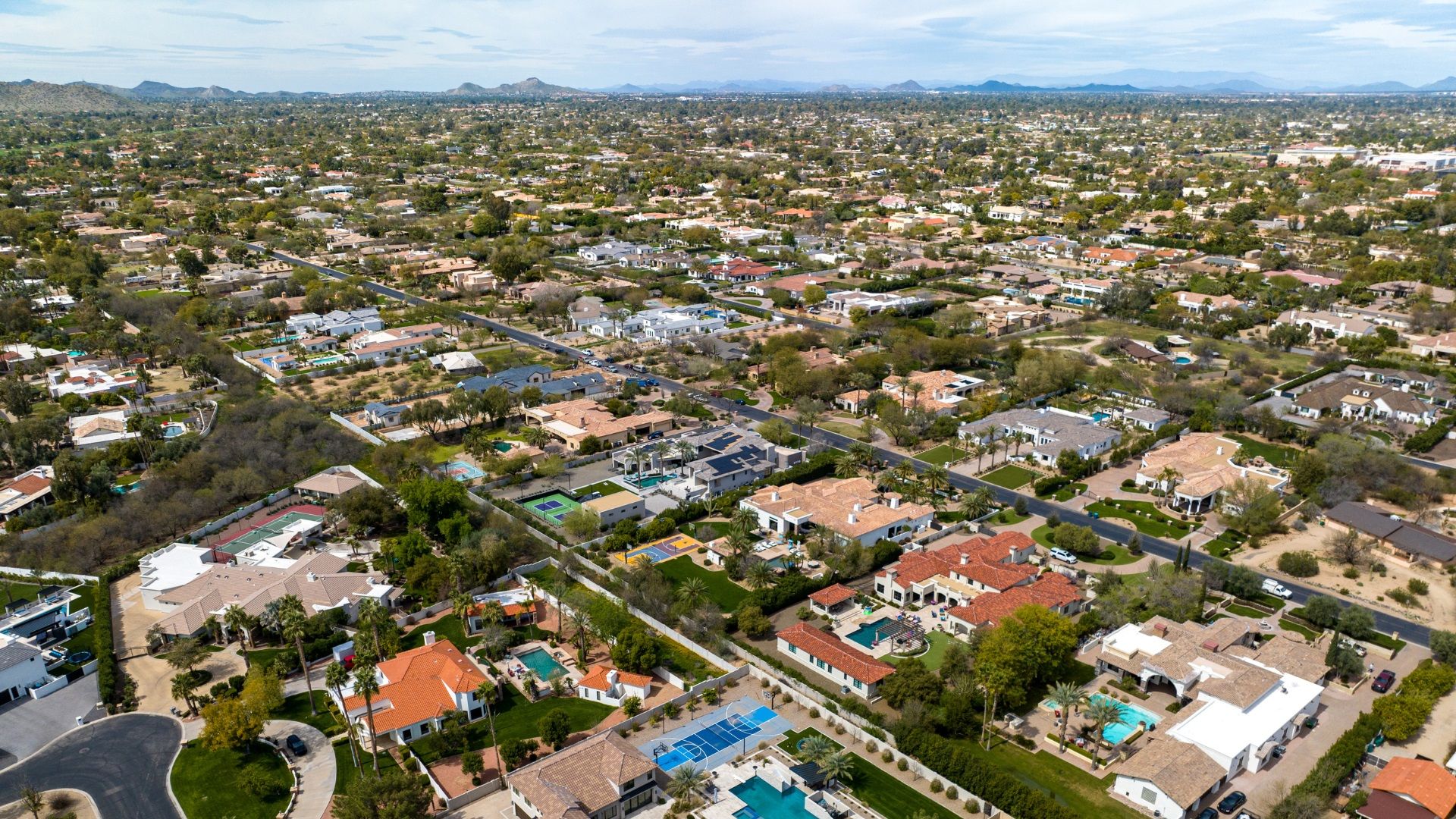 Aerial view of a vibrant residential neighborhood, showcasing spacious homes with pools and landscaped yards, ideal for short-term rental opportunities. Learn how to unlock maximum revenue with proven marketing strategies for your vacation rental or short-term rental.