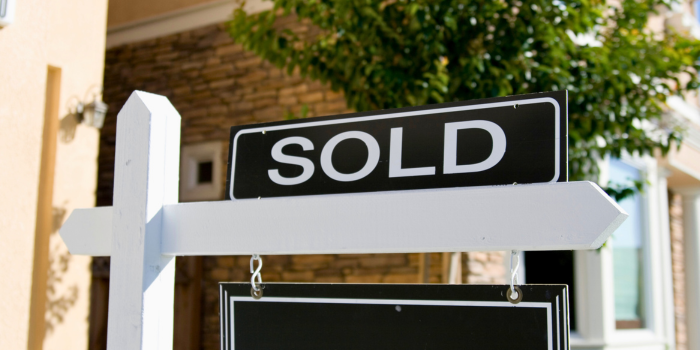 Image of a black 'Sold' sign in front of a home, representing scenarios where selling makes sense. The blog discusses strategic reasons to sell, including using proceeds for significant investments, repaying debt, avoiding rental risks, or addressing declining rental demand or costly repairs. It emphasizes the importance of having a clear financial plan for the proceeds.