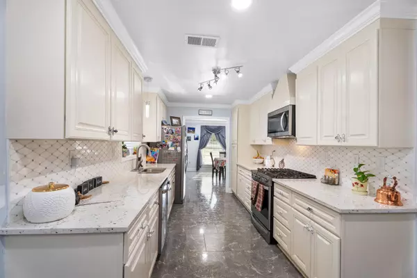 Full view of the kitchen at 408 Avenue A, Belle Chasse, LA, with gas range, matching appliances, and formal dining room entry.