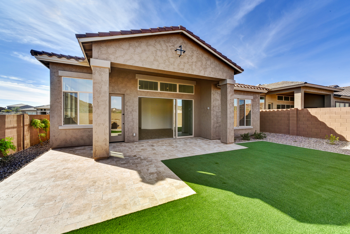 Exterior view of a high-quality new construction home in Peoria, Arizona, featuring durable 2x6 construction for enhanced structural integrity and energy efficiency. The modern design includes energy-efficient windows, a well-maintained yard, and a spacious layout, highlighting the craftsmanship and attention to detail in this premier property.