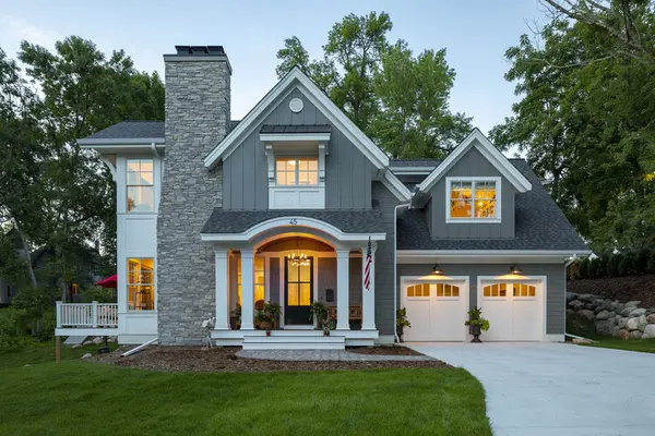 Two Story home with front chimney and double garage doors