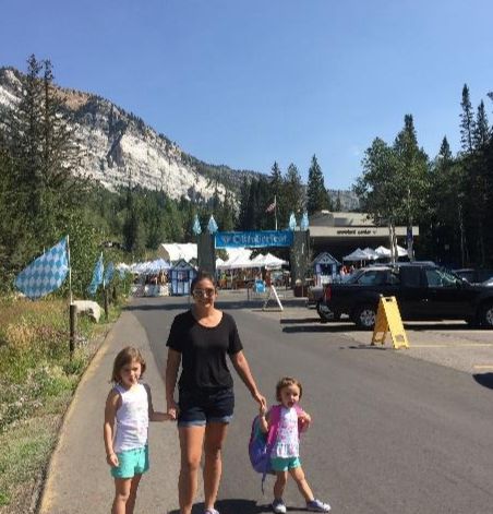 A person and two children walking on a streetDescription automatically generated