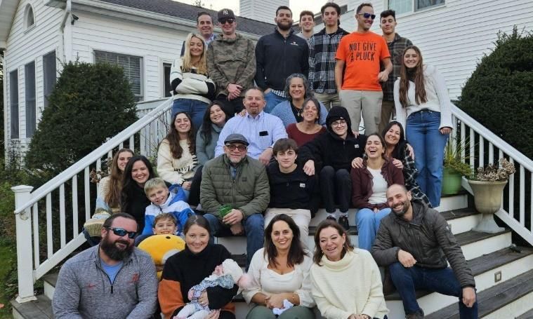 A group of people posing for a photo on a staircaseDescription automatically generated