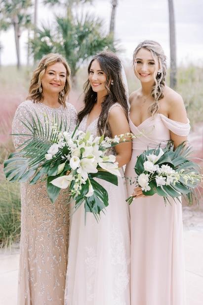 A group of women in dresses holding flowersDescription automatically generated