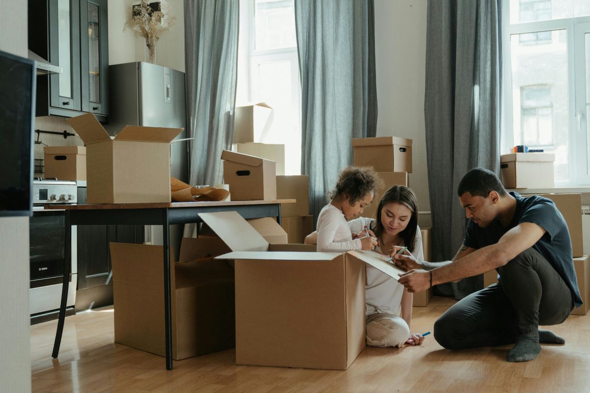 A family on the floor surrounded by moving boxes