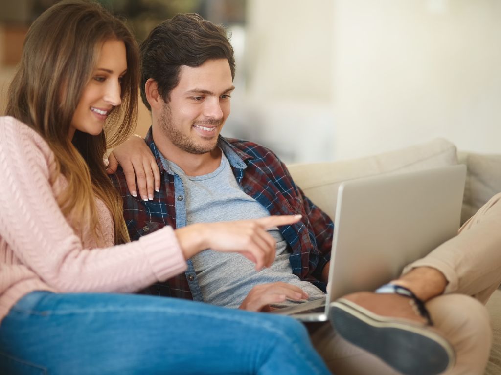 image of a couple looking at houses on a laptop