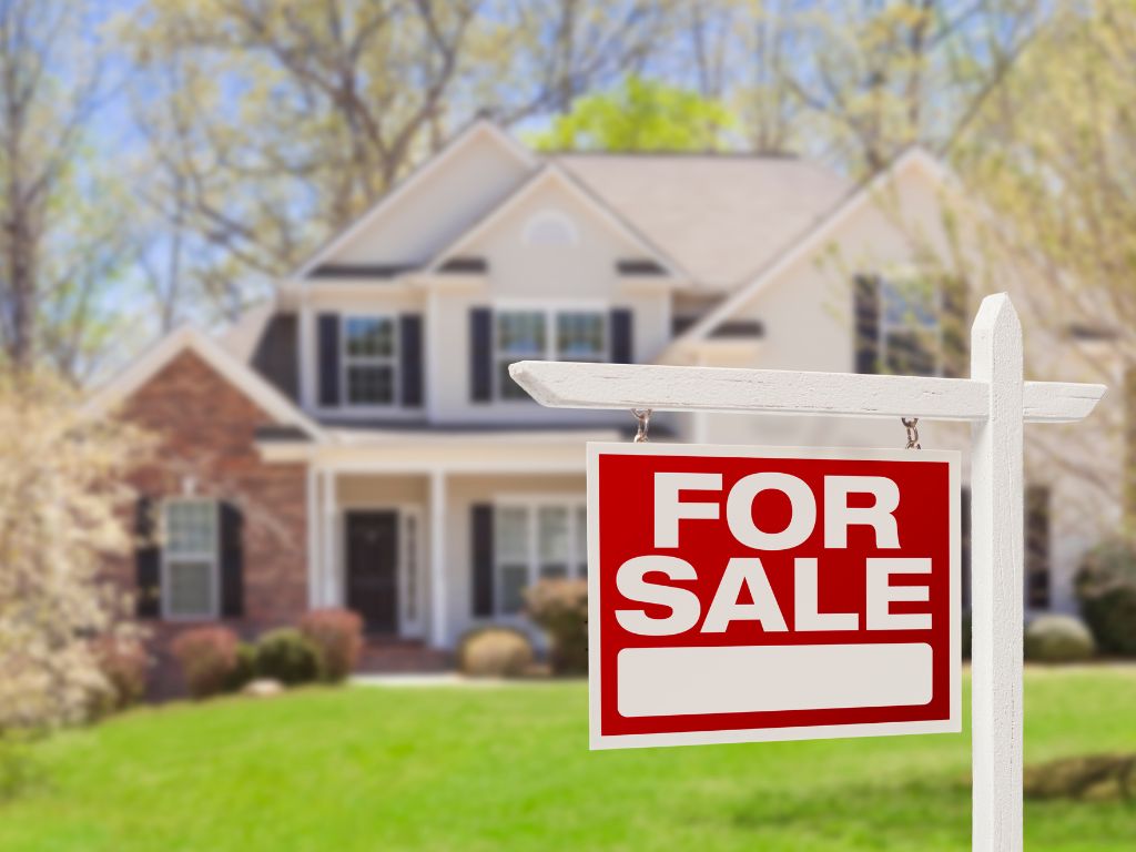 image of a home with a for sale sign in the yard