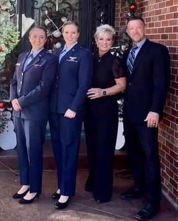 A group of people in uniform standing in front of a brick buildingDescription automatically generated