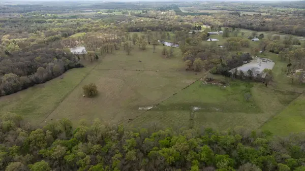Aerial view, rural ranch land, open pasture, scattered trees, ponds, commercial property, country home