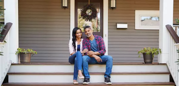 ext - couple on steps of front porch of house