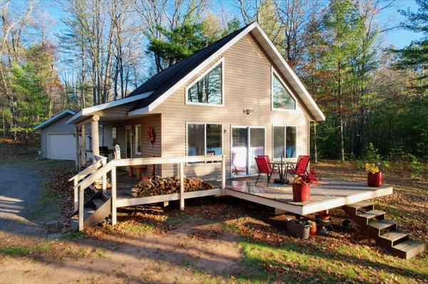 Our primary photo captures the most important features of a property - here it's the cabin, garage, plus the lake view displayed in the reflection on the lakeside windows. - Eliason Realty