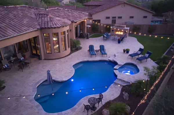 A high definition view of a desert landscaped backyard in Mesa Arizona, with a pool spa, outdoor fireplace and Kitchen.