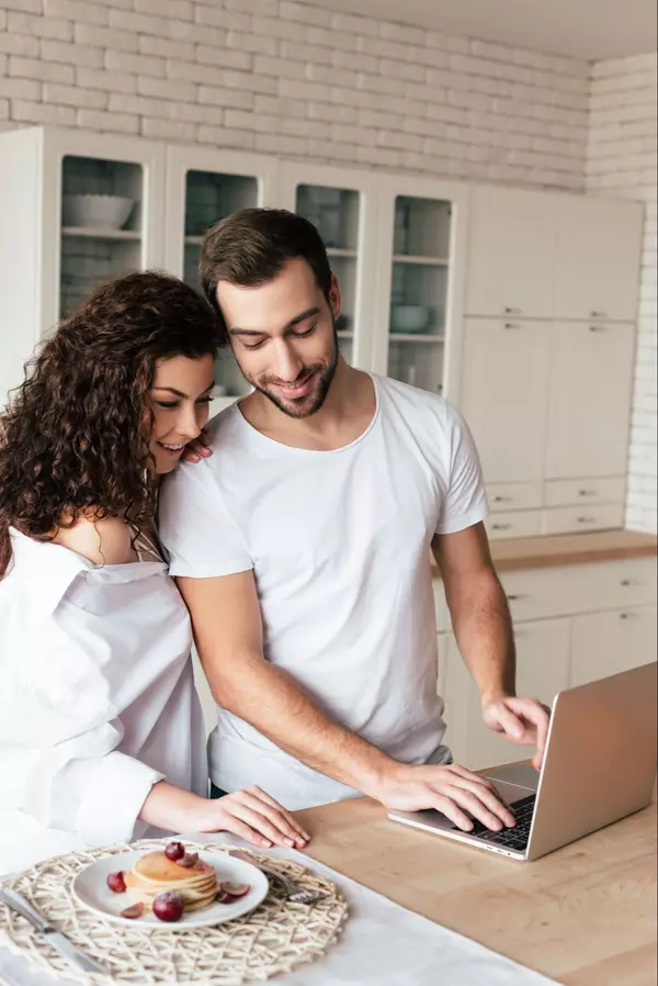 smiling-couple-using-laptop-during-breakfast-in-ki-2023-09-07-02-16-00-utc (1)
