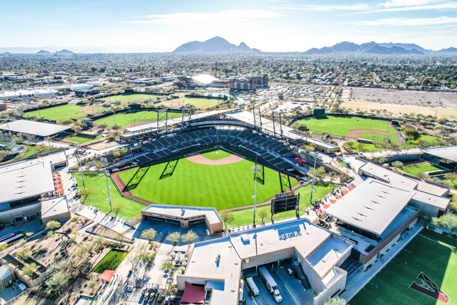 Aerial view of Salt River Fields at Talking Stick in Scottsdale, Arizona, home to MLB Spring Training for the Arizona Diamondbacks and Colorado Rockies. The picturesque stadium, surrounded by lush green fields and mountain views, showcases Scottsdale’s premier sports destination for baseball fans.