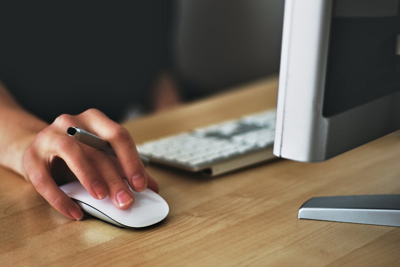 A person holding an Apple magic mouse.