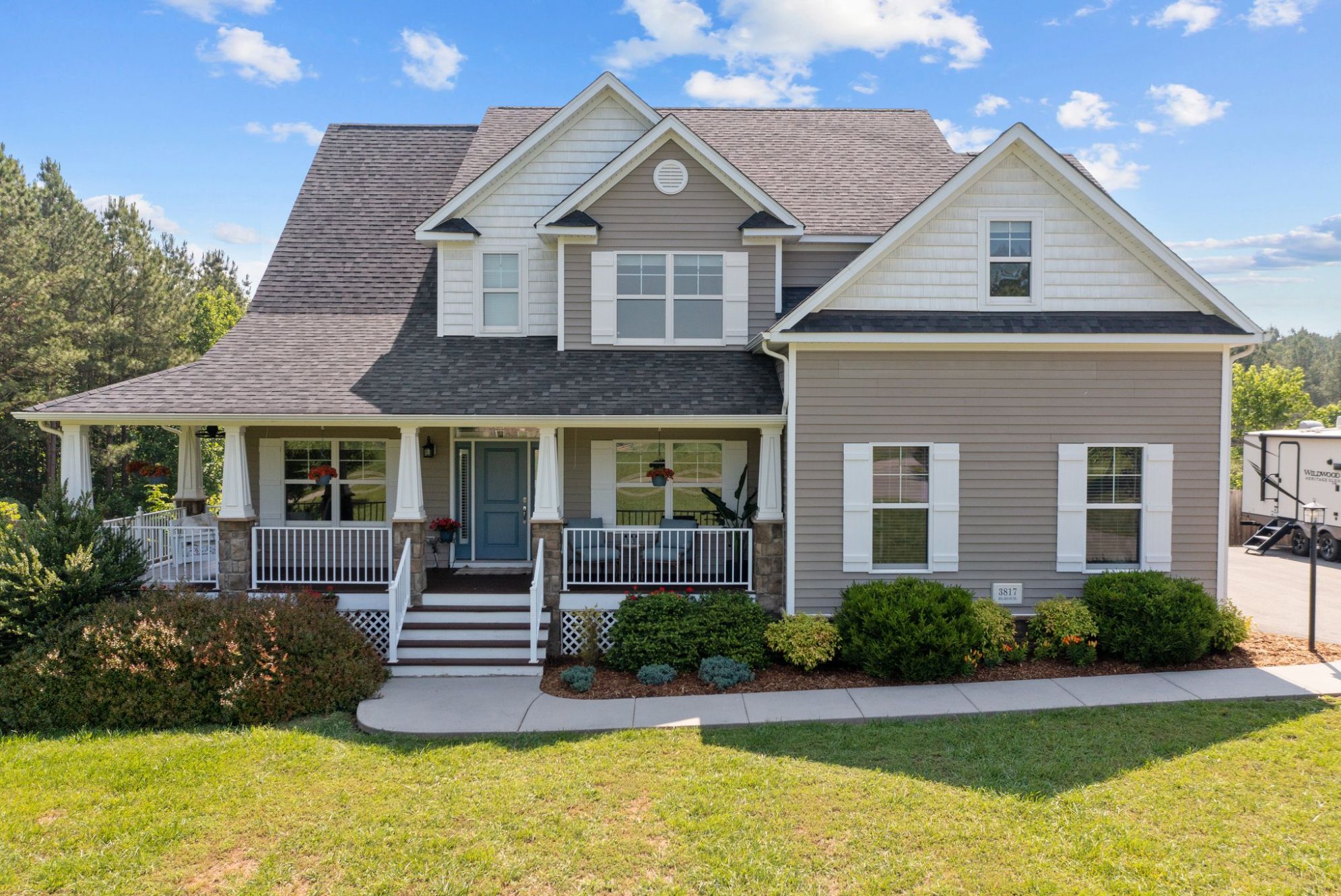 Front view of a beautiful two-story home with a large porch, located in Powhatan Virginia. This property is part of a real estate listing by Jacquelyn Waters, Real Broker LLC