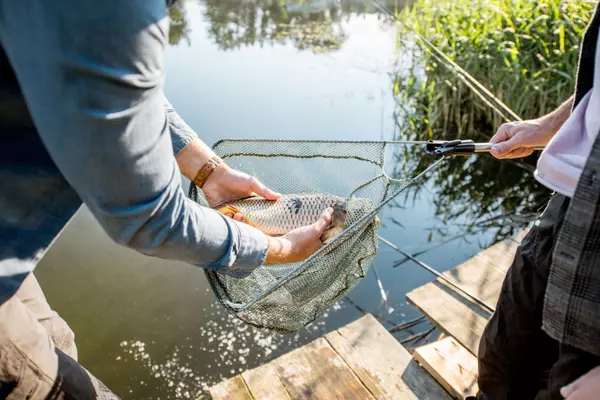 fisherman-getting-fish-from-the-net-2023-11-27-04-50-01-utc