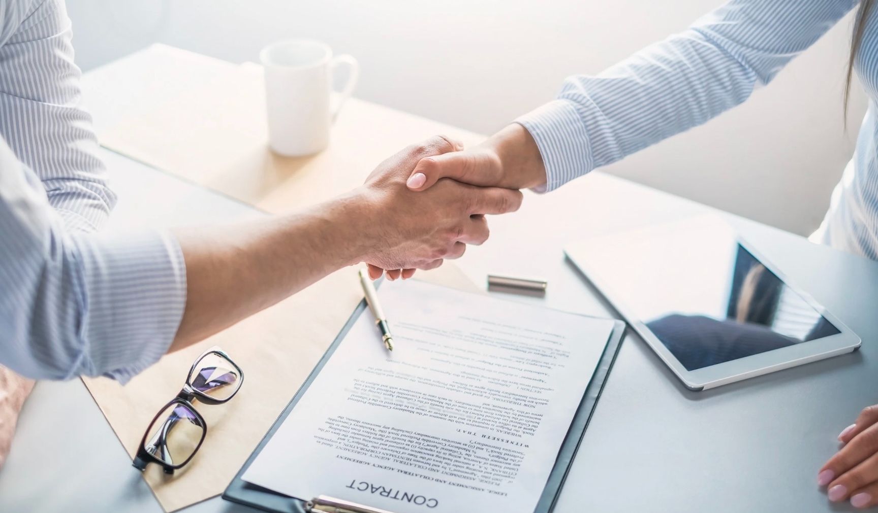 People shaking hands after negotiating a successful offer by Evan Karam