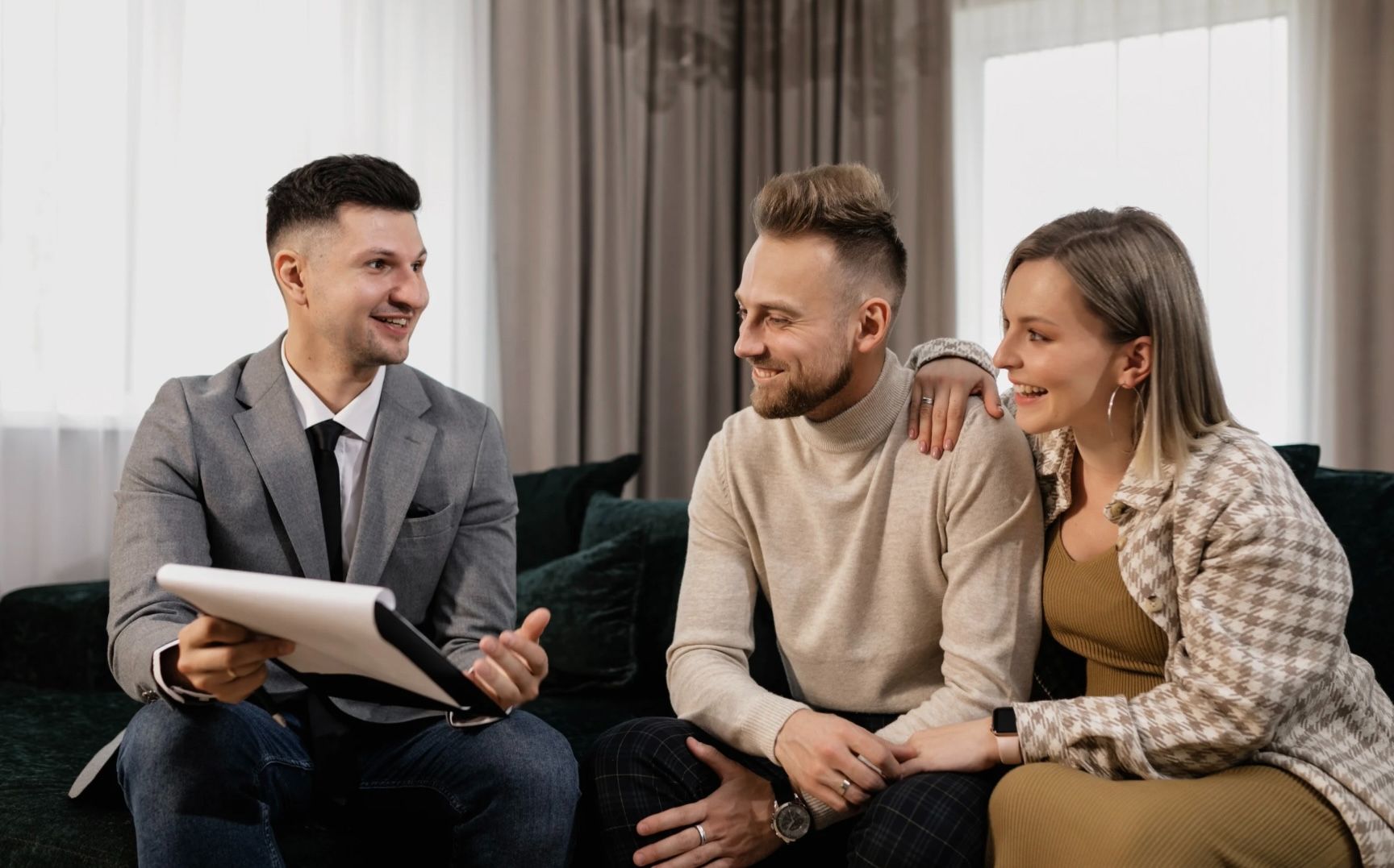 A realtor and his clients sitting down reviewing multiple offers with confidence