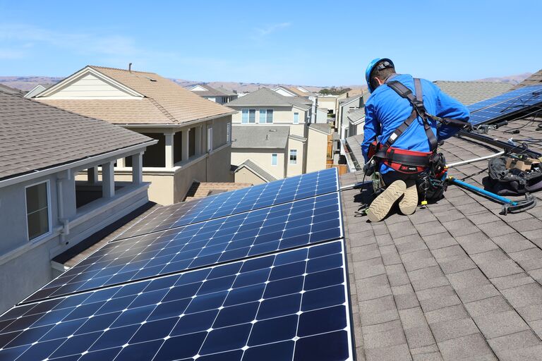 Man on top of a rooftop with solarpanel