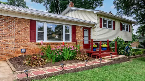 Colorful home entryway with red accents and vibrant garden 103 Deal Ave 