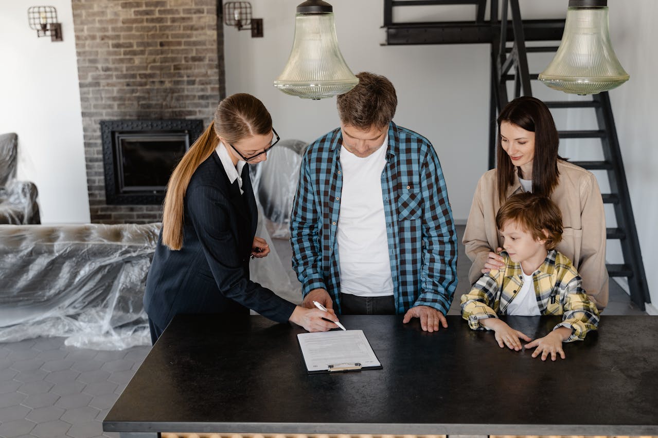 Man signing papers with the help of a real estate agent