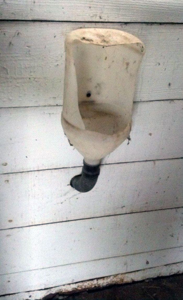 Creative DIY urinal made from a repurposed milk jug, cut open for use as a makeshift bathroom solution.