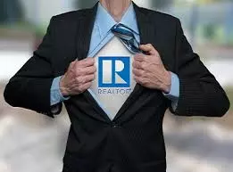 Person in a suit pulling open their shirt to reveal a REALTOR® logo underneath, symbolizing dedication and professionalism in the real estate industry.