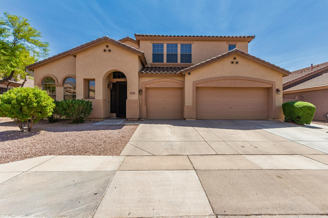 Exterior view of a luxurious 5-bedroom home in Augusta Ranch, Mesa, AZ, featuring modern design, a well-manicured front yard, and a spacious 3-car garage.