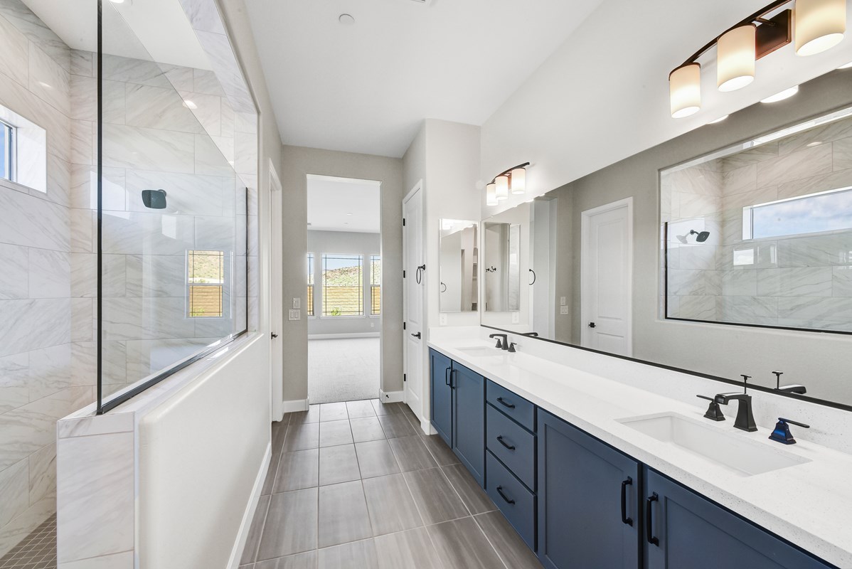 A luxurious, spa-like bathroom sanctuary featuring a large walk-in shower with floor-to-ceiling tiles, creating a serene atmosphere. The space includes a spacious walk-in closet and elegant quartz countertops, enhancing the sophistication and comfort of this en-suite retreat