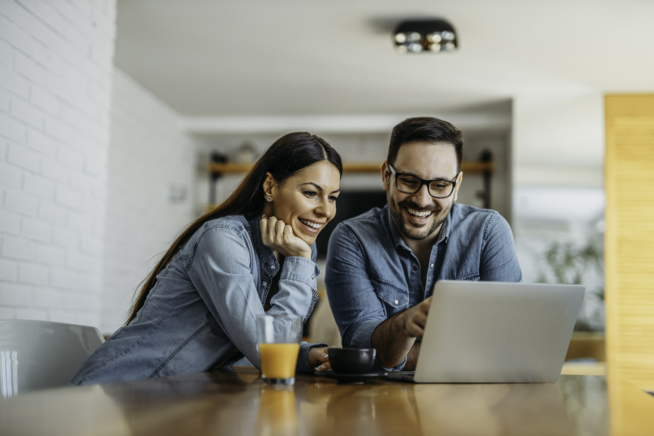 portrait-of-a-cute-smiling-couple-looking-at-lapto-2022-12-18-17-32-45-utc