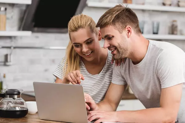 stock-photo-couple-looking-laptop-together-kitchen