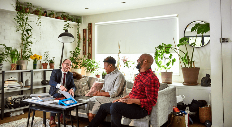 real estate agent sitting in living room with 2 people laughing