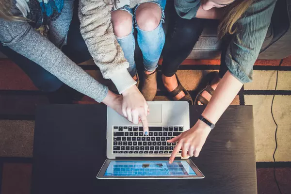Home buyers reviewing MLS listings together on laptop during real estate search