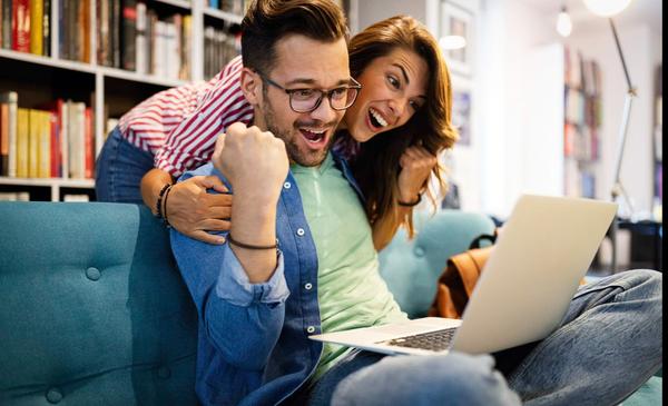 surprised-happy-young-couple-looking-at-laptop-2021-08-27-08-39-35-utc (1)