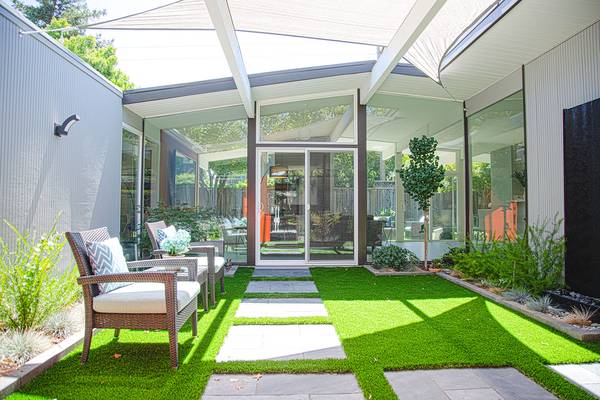 Eichler atrium garden with glass walls and outdoor seating